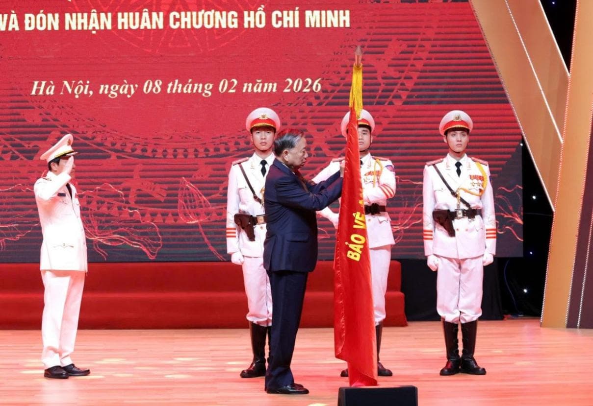 Tổng Bí thư Tô Lâm gắn Huân chương Hồ Chí Minh lên Lá cờ truyền thống của lực lượng Tình báo CAND. Ảnh: Công an nhân dân.